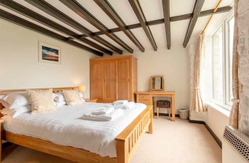 Double bed in a room with wooden beams on the ceiling